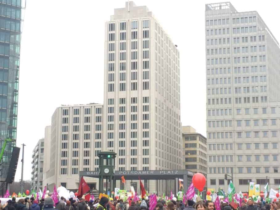 Das bunte Treiben der Demo vor der imposanten Silhouette des Potsdamer Platz